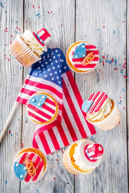 Cupcakes patrióticos dos eua sobre bandeiras na mesa de madeira