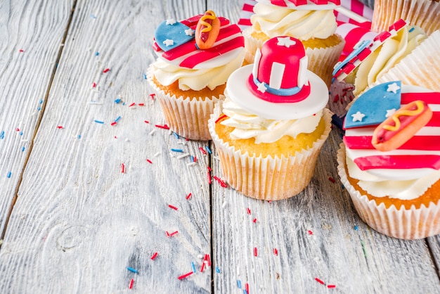 Cupcakes patrióticos dos EUA sobre bandeiras na mesa de madeira