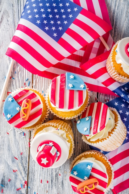 Cupcakes patrióticos dos EUA sobre bandeiras na mesa de madeira