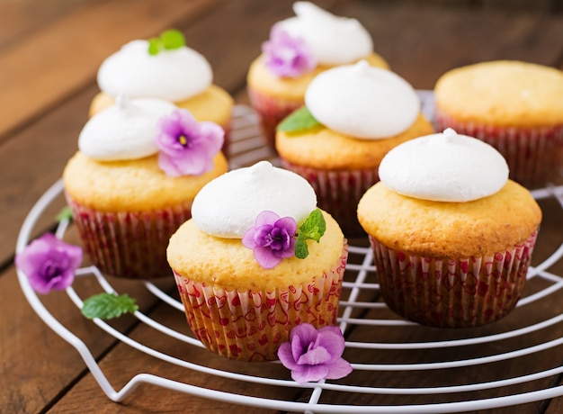 Cupcakes de queso cottage con merengue flor decorada y hojas de menta