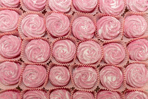 Cupcakes rosa en filas, fondo de postre dulce.