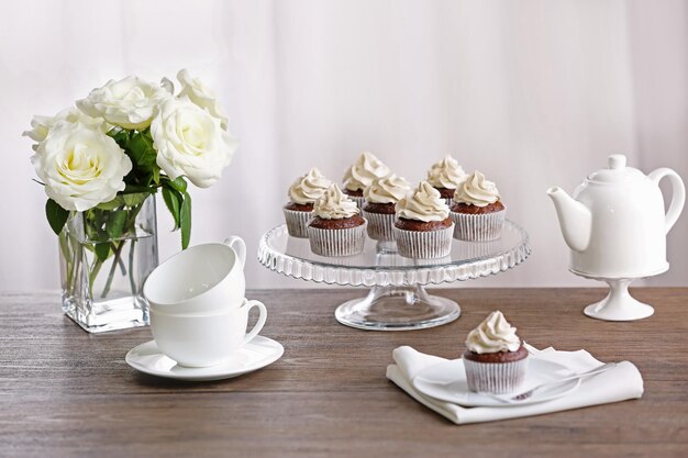 Foto cupcakes saborosos com rosas em suporte