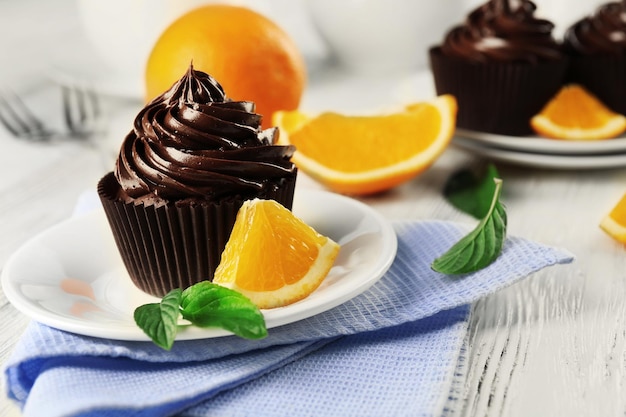 Cupcakes servidos com laranja e bebida na mesa