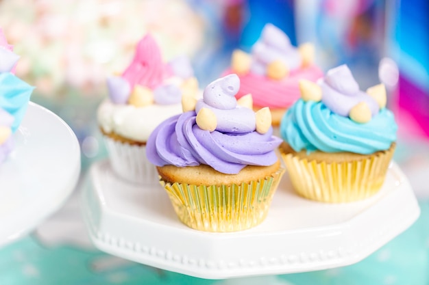 Cupcakes de unicornio multicolor en la fiesta de cumpleaños de la niña.