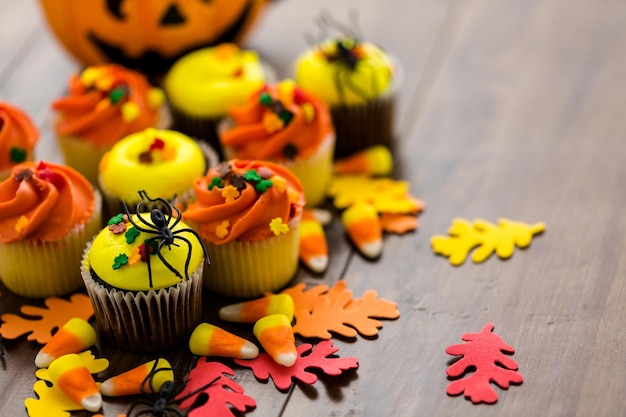 Cupcakes variados com glacê amarelo e laranja, decorados para o outono.