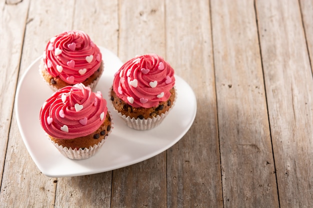 Cupcakes verziert mit Zuckerherzen zum Valentinstag auf Holztisch