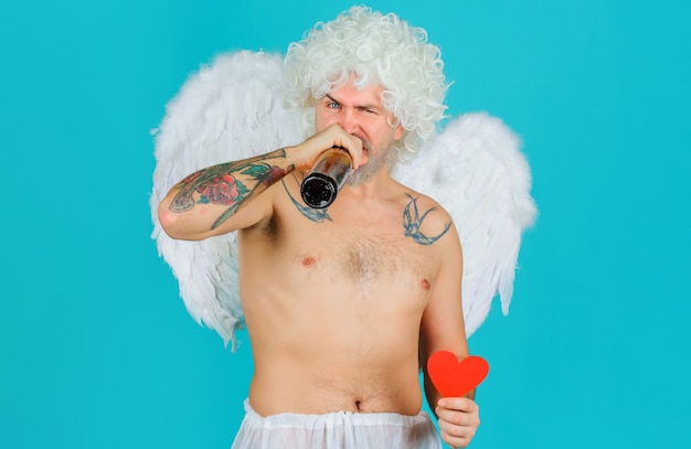 Cupido barbudo bebiendo cerveza, hombre ángel con alas con botella de cerveza, celebración del día de San Valentín.