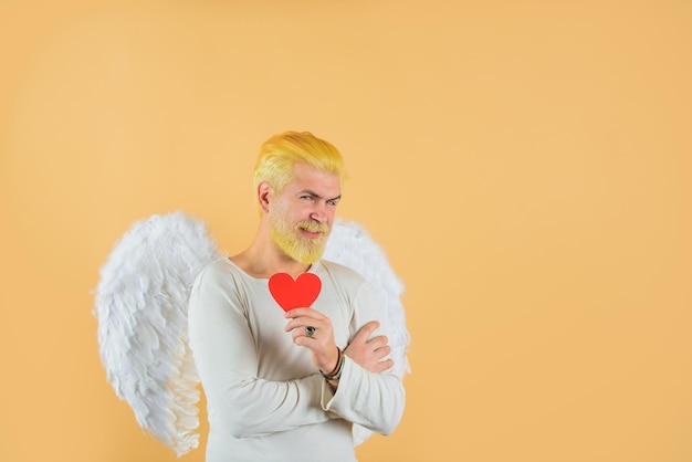 Cupido sostiene valnetines corazón hermoso Cupido día de San Valentín ángel hombre con alas blancas concepto de amor