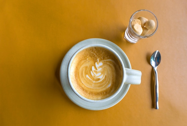 Cuplatte café na mesa de couro amarelo