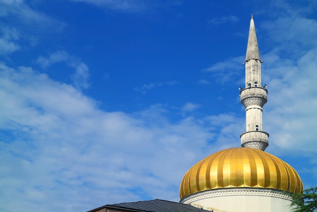 Cúpula dorada y ornamentado minarete de la mezquita de Batumi contra el vibrante cielo azul, Batumi, Adjara, Georgia