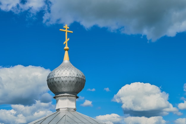 La cúpula de la Iglesia Ortodoxa con cruz contra el cielo azul