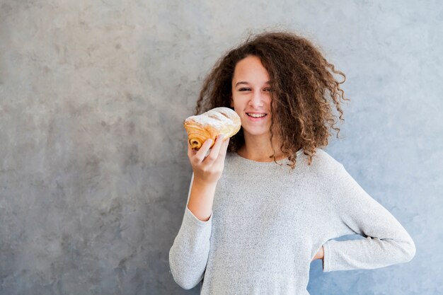 Curar el pelo rizado niña comiendo croissant