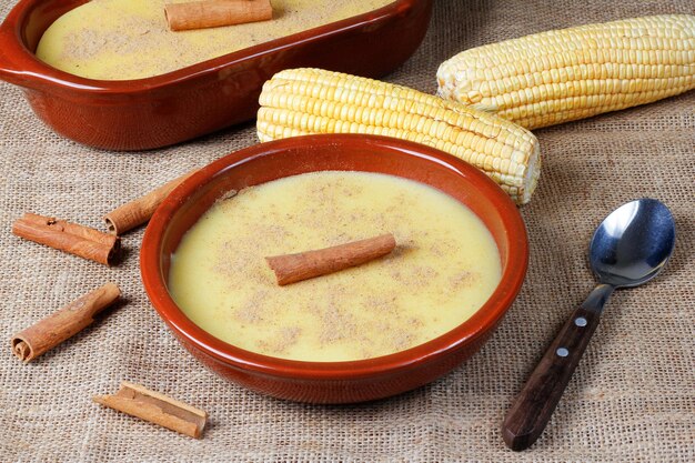 Foto curau-creme aus mais, süßes und typisches dessert der brasilianischen küche auf einem holztisch