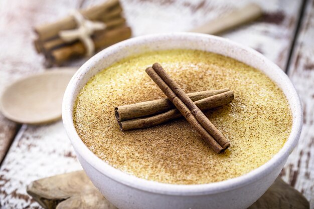 Curau, doce típico do estado de Minas Gerais, feito no Brasil, servido e decorado com canela, cozinha rústica e rural