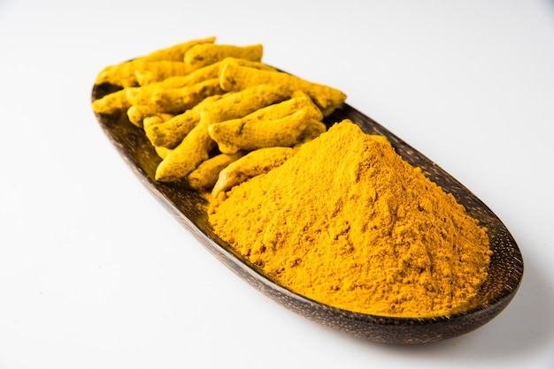 Cúrcuma inteira e pilha de pó de haldi ou huldi