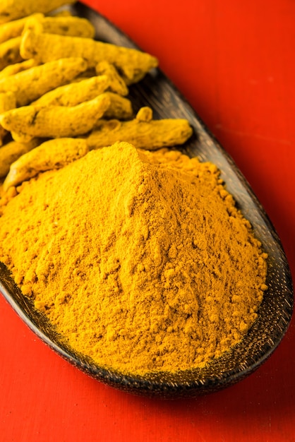 Cúrcuma inteira e pilha de pó de haldi ou huldi