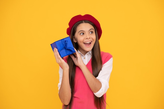 Curiosa adolescente feliz em boina francesa segura presente ou caixa de presente feliz aniversário