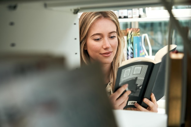 Curioso jovem estudante procurando um livro em uma biblioteca em um dia ensolarado de primavera