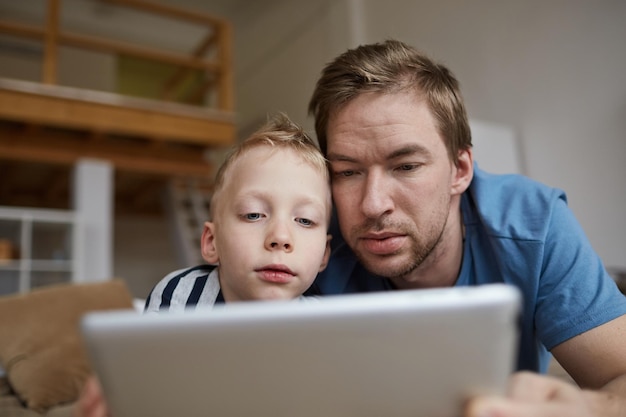 Curioso pai e filho assistindo filme no tablet