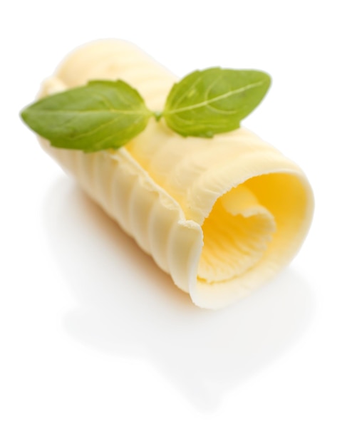 Curl de mantequilla fresca con albahaca aislada en blanco
