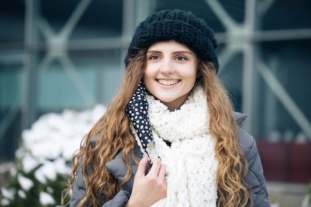 Curly Frau nimmt medizinische Maske ab.