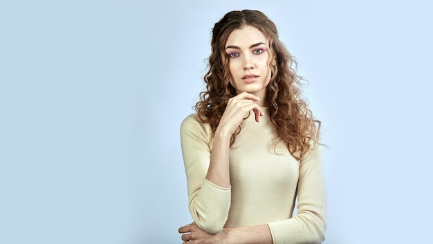 Curlyhaired Model posiert mit Blick auf die Kamera