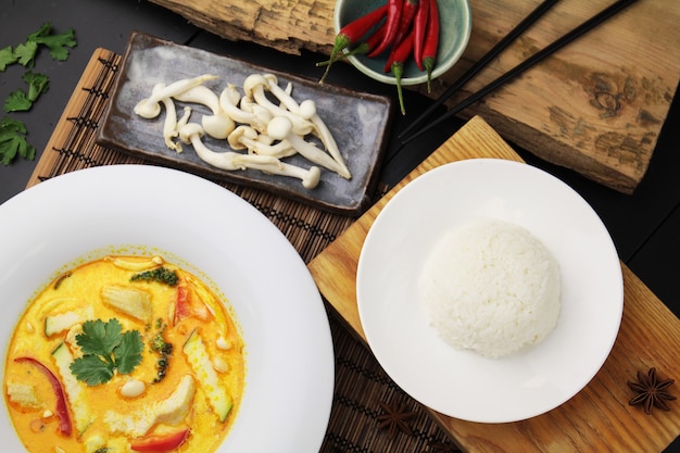 Curry amarelo com frango em um grande prato branco, arroz e pauzinhos, vista de cima