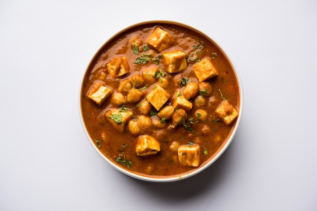 Curry Chole Paneer elaborado con garbanzos hervidos con requesón con especias. Receta popular del norte de la India. servido en un tazón o fuente para servir. Enfoque selectivo