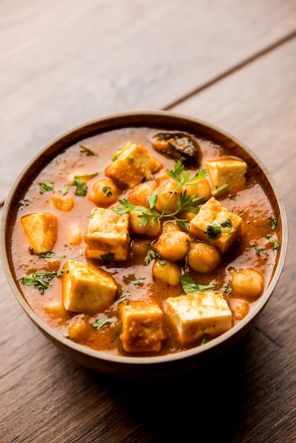 Curry Chole Paneer elaborado con garbanzos hervidos con requesón con especias. Receta popular del norte de la India. servido en un tazón o fuente para servir. Enfoque selectivo