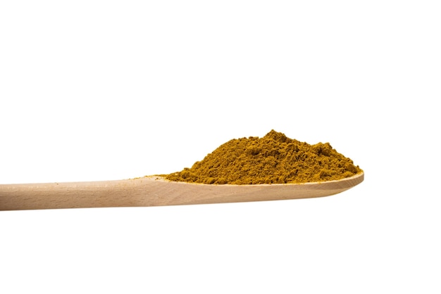 Curry en cuchara de madera aislado sobre fondo blanco.