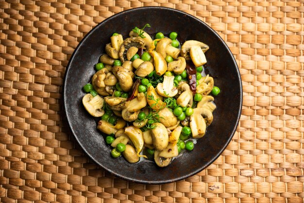 Curry de cogumelos e ervilhas com alho assado, comida indiana servida em uma tigela