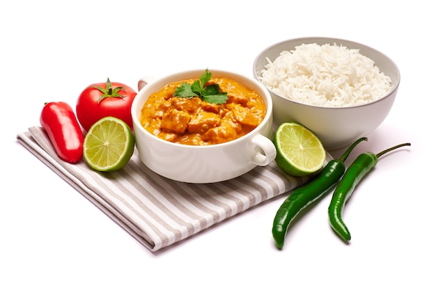 Curry de frango tradicional e uma tigela de arroz cozido isolado