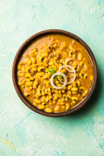 Curry de frijoles de ojos negros servido en un tazón con Naan y arroz