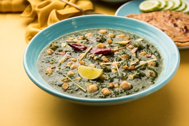 Curry de garbanzos y espinacas o Chana Masala con Palak servido con arroz y pan plano o Paratha, enfoque selectivo
