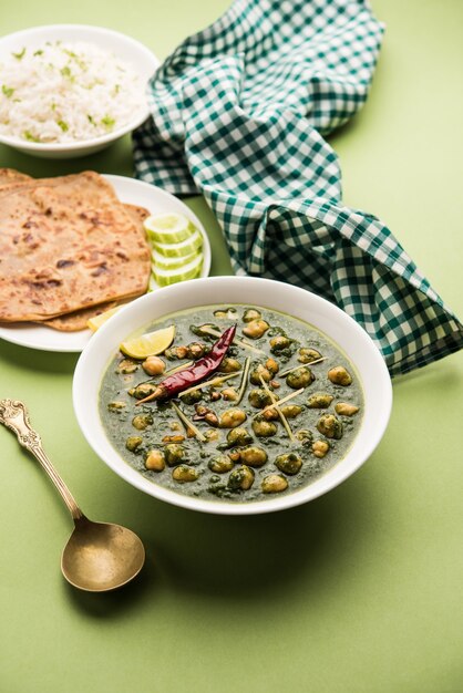 Curry de garbanzos y espinacas o Chana Masala con Palak servido con arroz y pan plano o Paratha, enfoque selectivo