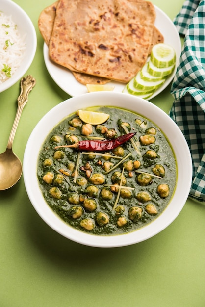 Curry de garbanzos y espinacas o Chana Masala con Palak servido con arroz y pan plano o Paratha, enfoque selectivo