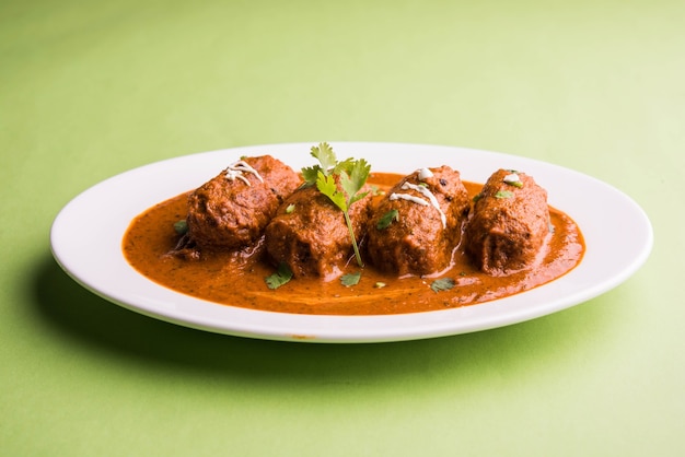 curry malai kofta - plato clásico del norte de la India. Alternativa vegetariana a las albóndigas servidas con tandoori roti o pan indio y ensalada verde, enfoque selectivo