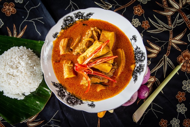 Curry de pescado curry de pescado tradicional de Malasia plato especial de kerala con coco dispuesto en un blanco