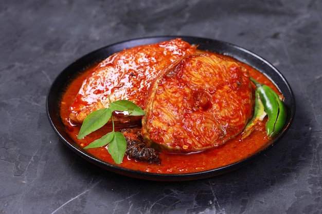 Curry de pescado vidente Curry de pescado indio dispuesto en un tazón negro adornado con tamarindo malabar