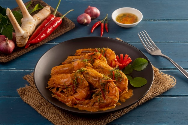 Curry rojo seco frito con camarones en la mesa de madera estilo de comida tailandesa