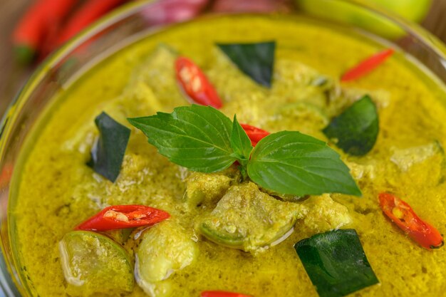 Foto curry verde em uma tigela em uma mesa de madeira