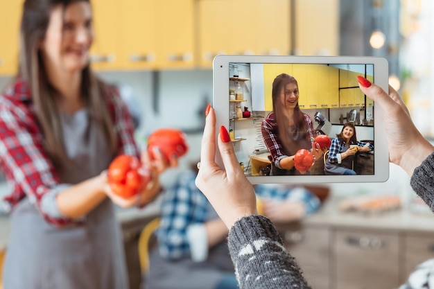 Curso de culinária divertido e fácil Nutrição saudável Assistente feminina gravando blog de vídeo com jovem segurando páprica