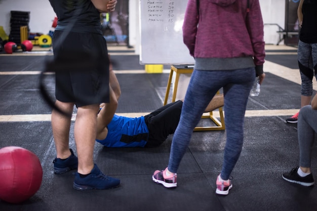 Curso de treinamento.grupo de jovens atletas recebendo instruções do treinador antes do exercício no ginásio cross fitness