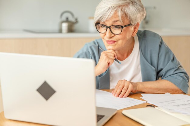 Cursos de educación en línea concepto de webinar mujer anciana de mediana edad que usa una computadora portátil escribiendo