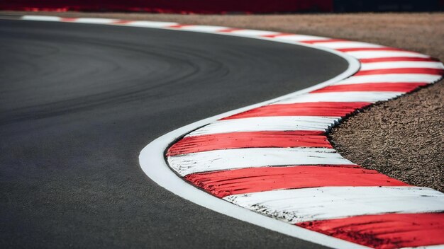 Foto curva de asfalto rojo y blanco del bordillo de una pista de carreras detalle de deportes de motor circuito de carreras pista de carrera cur