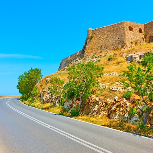 Curva da estrada e a fortezza de Rethymno, Creta, Grécia