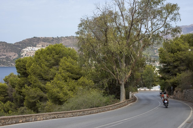 Curva fechada em uma perigosa estrada de alta montanha com céu nublado sobre o mar