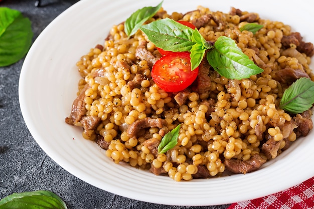 Cuscús israelí con carne de res. Comida sabrosa. Comida asiática