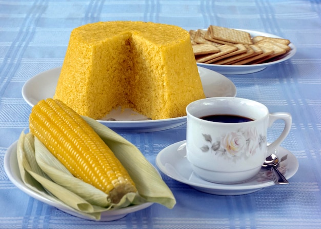 Cuscús de maíz en la mesa con una taza de café y mazorcas de maíz hervidas Comida de Brasil