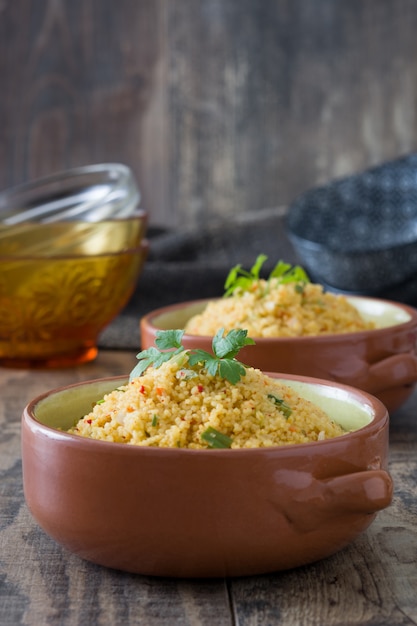 Foto cuscús con verduras en un recipiente en la mesa de madera